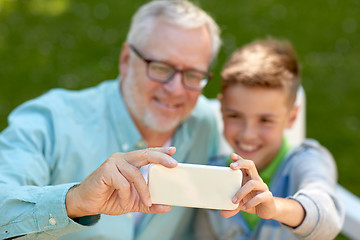 Image showing old man and boy taking selfie by smartphone