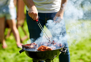 Image showing man cooking meat on barbecue grill at summer party