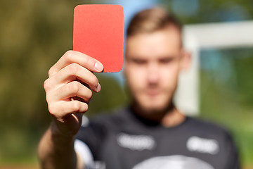 Image showing referee hands with red card on football field