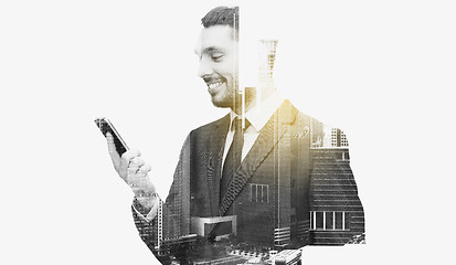 Image showing smiling businessman texting on smartphone