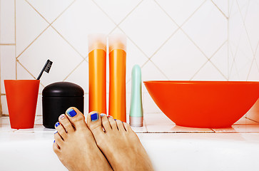 Image showing woman legs in bathroom with lot of stylish stuff for care, pedicure creative design, hygiene concept 