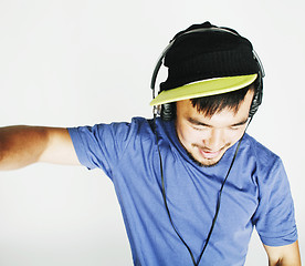 Image showing young asian man in hat and headphones listening music on white b