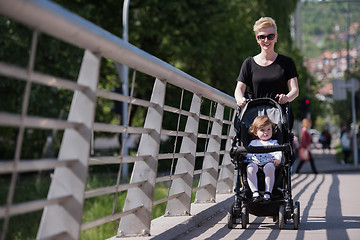 Image showing mother pushed her baby daughter in a stroller