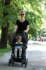 Image showing mother pushed her baby daughter in a stroller