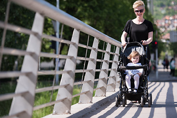 Image showing mother pushed her baby daughter in a stroller