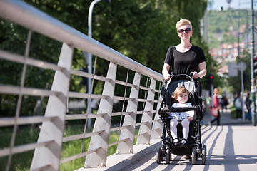 Image showing mother pushed her baby daughter in a stroller