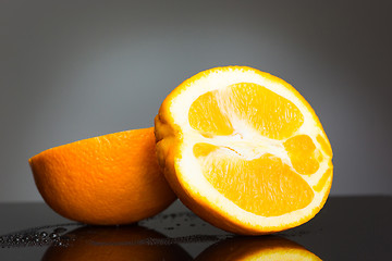 Image showing Sliced orange fruit on gray background