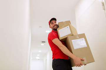 Image showing delivery man with parcel boxes in corridor