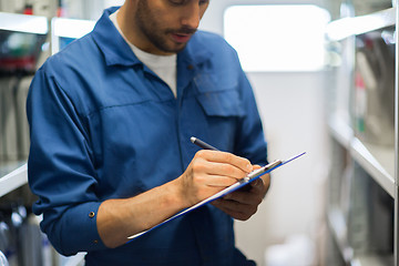 Image showing auto mechanic with clipboard at car workshop