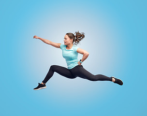 Image showing happy sporty young woman jumping in fighting pose