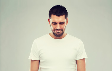 Image showing unhappy young man over gray background