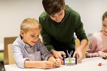 Image showing happy children building robots at robotics school