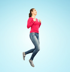 Image showing smiling young woman jumping in air