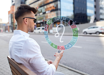 Image showing man with smartphone and zodiac signs in city