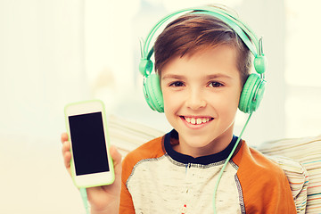 Image showing happy boy with smartphone and headphones at home