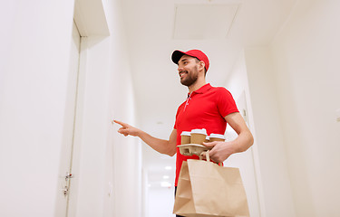 Image showing delivery man with coffee and food ringing doorbell