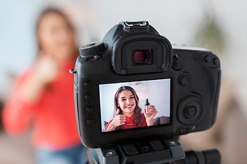 Image showing woman with foundation and camera recording video