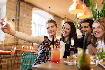 Image showing friends taking selfie by smartphone at bar or cafe