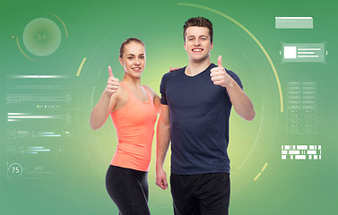 Image showing happy sportive man and woman showing thumbs up