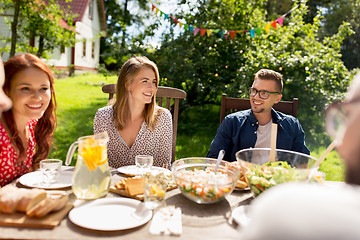 Image showing happy friends having dinner at summer garden party