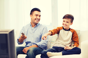 Image showing smiling father and son watching tv at home