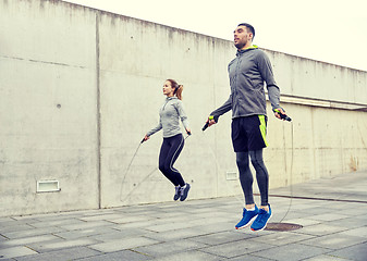 Image showing man and woman exercising with jump-rope outdoors