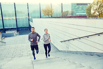 Image showing happy couple running upstairs on city stairs