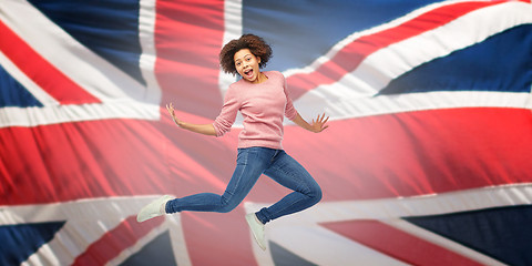 Image showing african american woman jumping over english flag