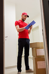 Image showing delivery man with boxes and clipboard at door