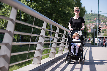 Image showing mother pushed her baby daughter in a stroller