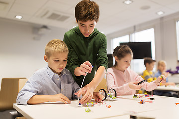 Image showing happy children building robots at robotics school