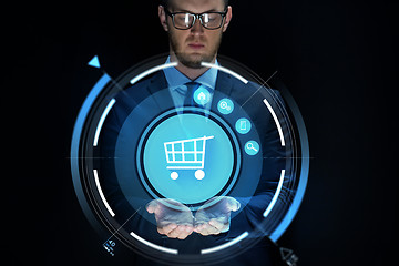 Image showing businessman with virtual shopping cart projection