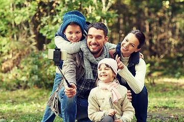 Image showing happy family with smartphone selfie stick in woods