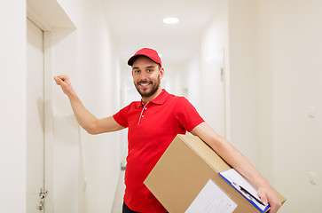 Image showing delivery man with parcel box knocking on door