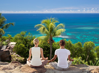 Image showing smiling couple making yoga exercises outdoors