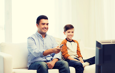 Image showing smiling father and son watching tv at home