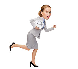 Image showing stressed young businesswoman with clock running