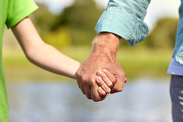 Image showing senior man and child holding hands