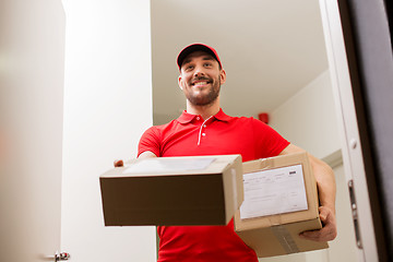 Image showing delivery man with parcel boxes at customer door