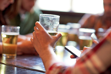 Image showing man with beer and smartphones at bar or pub