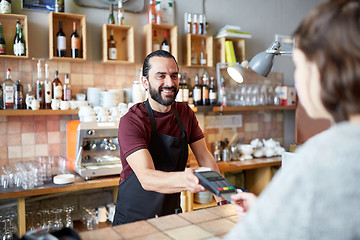 Image showing man or waiter with card reader and customer at bar