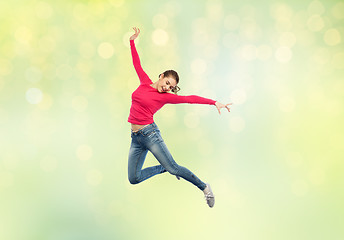 Image showing happy young woman jumping in air or dancing
