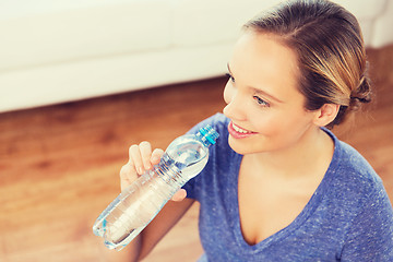 Image showing happy woman with water bottle at home