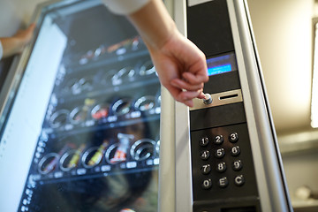 Image showing hand pushing button on vending machine