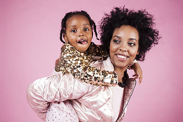 Image showing young pretty african-american mother with little cute daughter hugging, happy smiling on pink background, lifestyle modern people concept 