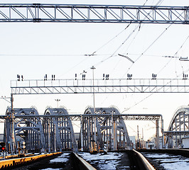 Image showing landscape with railway with trains, lot of steel rafters at sunset 