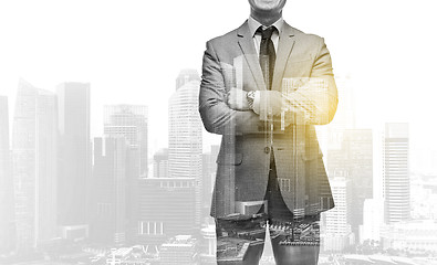 Image showing businessman with crossed arms over city buildings