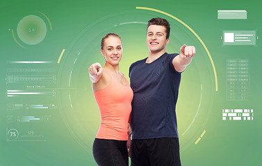 Image showing happy sportive man and woman pointing finger