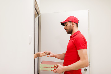 Image showing man delivering pizza to customer and taking money