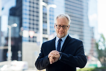 Image showing senior businessman checking time on his wristwatch